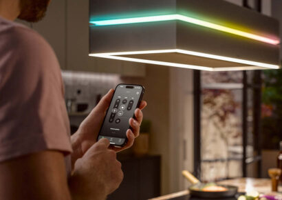 Ein Mann steuert eine smarte Küche mit dem Smartphone.