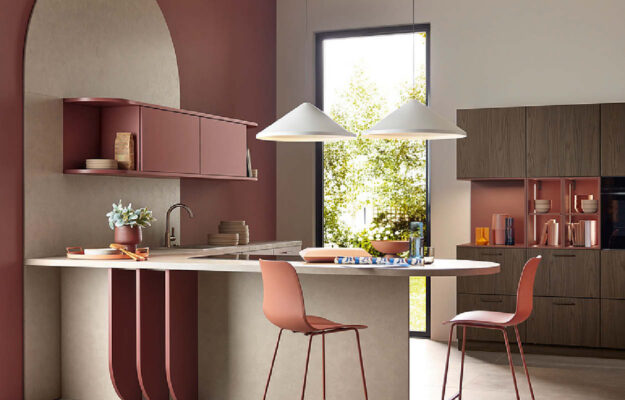 Küchen von Nolte bei VIVA Küchen – moderne Küche mit Kochinsel in warmen Rot- und Holztönen