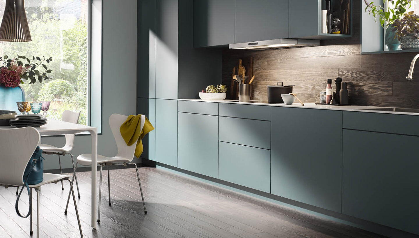 blaue Wohnküche mit Unterbau-Dunstabzug über Kochfeld