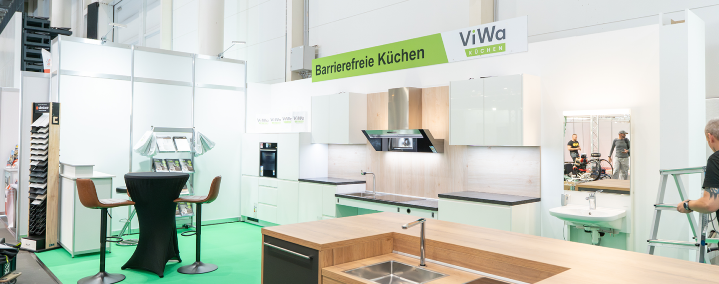 Barrierefreie Ausstellungsküche von ViWa Küchen mit ergonomischen Arbeitsflächen, Spüle, Kücheninsel, hellen Küchenmöbeln und integrierten Elektrogeräten für individuelle Küchenplanung.