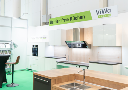Barrierefreie Ausstellungsküche von ViWa Küchen mit ergonomischen Arbeitsflächen, Spüle, Kücheninsel, hellen Küchenmöbeln und integrierten Elektrogeräten für individuelle Küchenplanung.