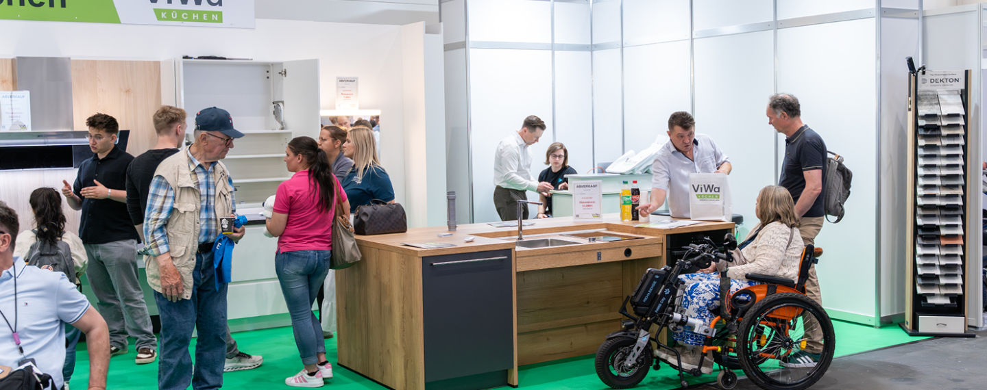 Barrierefreie Küche am ViWa-Messestand mit rollstuhlgerechter Kücheninsel, Spüle, großzügiger Bewegungsfläche und persönlicher Beratung zur individuellen Küchenplanung.